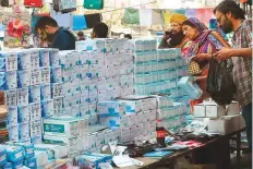  ?? AFP ?? Customers buy face masks at a stall in a market in Lahore.