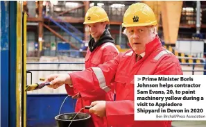  ?? Ben Birchall/Press Associatio­n ?? Prime Minister Boris Johnson helps contractor Sam Evans, 20, to paint machinery yellow during a visit to Appledore Shipyard in Devon in 2020