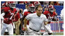  ??  ?? Alabama head coach Nick Saban leads his team onto the field for a game against Duke last season in Atlanta. Around the country, schools are taking the first cautious steps toward playing football through a pandemic.