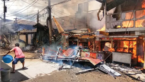  ??  ?? A resident tries to put out the fire that hit Lower Sampaguita, Brgy Banilad in Mandaue City yesterday. ALDO NELBERT BANAYNAL