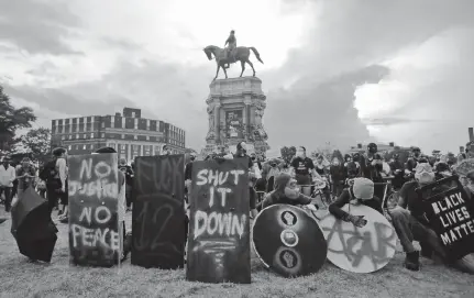  ?? ASSOCIATED PRESS FILE PHOTO ?? Protesters wait for police action as they surround the statue of Confederat­e Gen. Robert E. Lee on Monument Avenue in Richmond in June. The state ordered the area around the statue closed from sunset to sunrise, but the protesters had no plans to disperse.