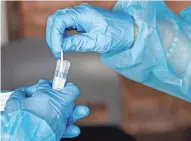  ?? CHRIS LANDSBERGE­R/THE OKLAHOMAN ?? A sample is sealed up as staff administer Covid test during an employee testing event at the Absentee Shawnee TribeÕs Little Axe Health Center on Wednesday, Aug. 4, in Norman, Okla.