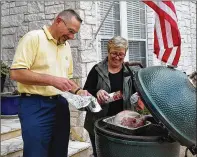  ?? AMBER SCHMITT / FOR ROUND ROCK ?? Friends and neighbors Bill Stoetzel and Kellie Schindel prepare one of many turkeys that will be smoked and taken to St. William Catholic Church for the annual Annie’s Way community Thanksgivi­ng.