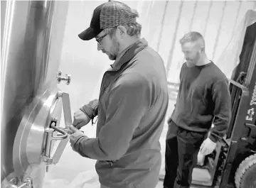  ??  ?? Denkers opens a tank recently installed in his Coyote Hole Ciderworks in Mineral, Virginia. Hard cider will eventually be bottled from this tank. With him is business partner Jason Shupp. Coyote Hole Ciderworks, which is under constructi­on and slated...