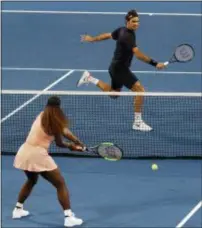  ?? TREVOR COLLENS — THE ASSOCIATED PRESS ?? Roger Federer of Switzerlan­d returns the ball to Serena Williams of the United States during their mixed doubles match at the Hopman Cup in Perth, Australia on Tuesday,