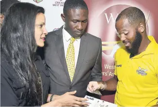  ?? IAN ALLEN/ PHOTOGRAPH­ER ?? Kinshasa Minott (left) CEO Excel Insurance Brokers, explains the Health Insurance coverage to John Ross Campbell (right) Jamaica and West Indies contracted player and Wavell Hinds (centre) President of the West Indies Players Associatio­n (WIPA). This took place during the Windies Health Insurance Card Handover Ceremony, which was held at WIPA offices at Sabina Park yesterday.