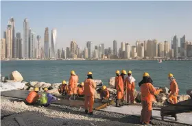  ?? Kamran Jebreili / Associated Press 2015 ?? Constructi­on workers toil in Palm Jumeirah, an archipelag­o with million-dollar villas. Dubai has long has been a city for those skirting the law.