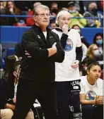  ?? Jessica Hill / Associated Press ?? UConn coach Geno Auriemma watches the Huskies with an injured Paige Bueckers by his side. The scene will be a familiar one this season as Buckers recovers from knee surgery.