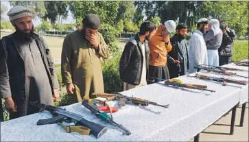  ?? Noorullah Shirzada AFP/Getty Images ?? FORMER Taliban fighters prepare to hand over weapons as part of a peace process in Jalalabad, Afghanista­n.