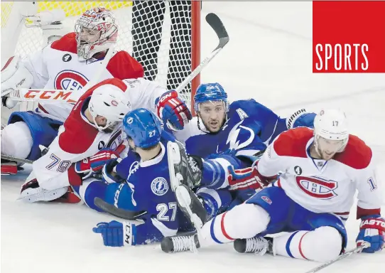 ?? DARIO AYALA/MONTREAL GAZETTE ?? Montreal and Tampa Bay players pile up in front of Carey Price during Game 4 of their Eastern Conference semifinal series Thursday in Tampa.