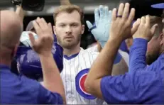  ?? Kin Cheung/Associated Press ?? The Cubs’ Ian Happ celebrates a solo home run with teammates in the dugout during the third inning Saturday against the Cardinals in London.