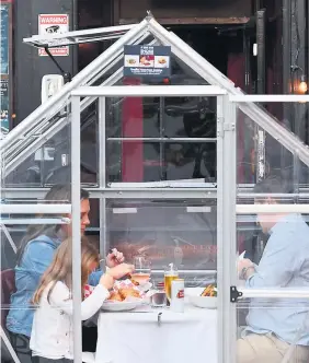  ?? PHOTO AFP ?? Une famille mange à l’intérieur de l’une des tentes en plastique anti-COVID d’un restaurant de Manhattan, à New York.