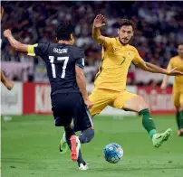  ?? — AFP file ?? Japan’s Makoto Hasebe fights for the ball with Australia’s Mathew Leckie during a World Cup qualifying match.