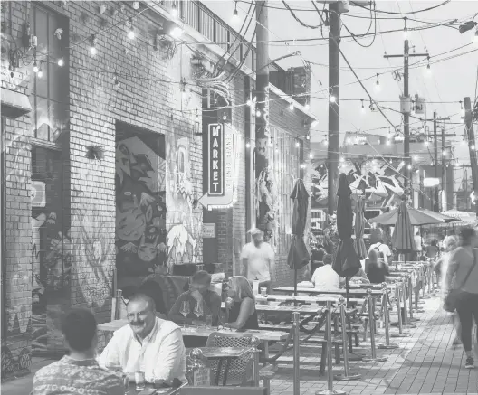  ?? JAMES STUKENBERG/THE NEW YORK TIMES ?? Patrons dine Aug. 5 in an alleyway in Rino, an arts district made up of portions of five neighborho­ods in north Denver.