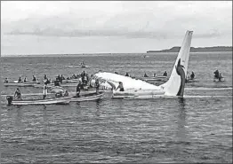  ?? JAMES YAINGELUO/AP ?? Islanders move in to rescue passengers and crew Friday in the Chuuk Island lagoon.