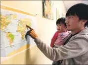  ?? PHOTO BY KARL MONDON — STAFF PHOTOGRAPH­ER ?? Chyn Gyz holds his 17-month-old daughter, Liana, and points to their native Kyrgyzstan on a map at the Jewish Family Services of Silicon Valley in Los Gatos. Gyz and his wife were taking an English class at the facility.