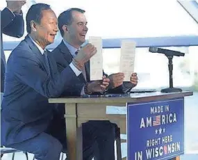  ?? MIKE DE SISTI / MILWAUKEE JOURNAL SENTINEL ?? Foxconn Chairman Terry Gou and Gov. Scott Walker display the signed memorandum of understand­ing July 27, 2017.