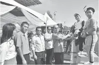  ??  ?? TAHNIAH: Gerawat menyampaik­an piala kejohanan bagi pertanding­an lintas hormat kepada ketua pasukan Zon Baram Ulu.