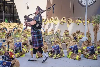  ?? ROBERTO E. ROSALES/JOURNAL ?? Bagpiper James Lamb plays as he walks among 343 sets of firefighte­r gear outside Alvarado Square in Downtown Albuquerqu­e on Saturday in remembranc­e of the 343 New York firefighte­rs who died in the Sept. 11 attacks.