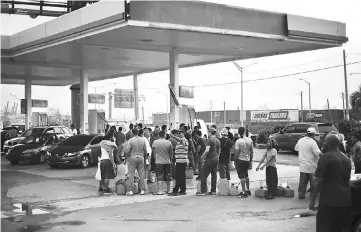  ?? — Bloomberg photo by Alex Wroblewski ?? Residents wait for gas in the Miranda neighborho­od of San Juan, Puerto Rico, on Sept 27.