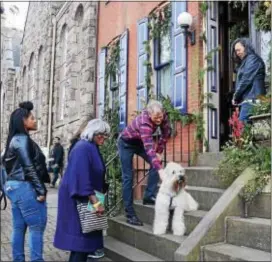  ?? PHOTOS BY GREGG SLABODA — THE TRENTONIAN ?? David Henderson with his dog Lightning greets people outside his Mercer St. house during the 51st Annual Mill Hill Holiday House Tour on Saturday.