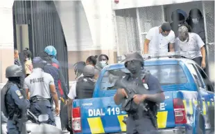  ?? RUDOLPH BROWN ?? Some of the alleged 33 members of the Clansman Gang alight from a truck before entering the Home Circuit Court in downtown Kingston.