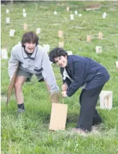  ?? ?? Isaac Jarden and Santiago Sanchez protecting a new tree with a plant guard. PHOTO: Supplied.