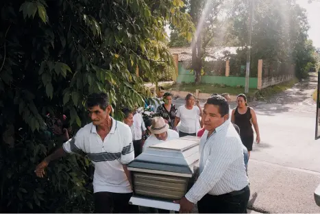  ??  ?? Friends and family at the funeral of a bus driver who was shot and killed during an encounter with a gang member as he was returning from his daily route, Apopa, El Salvador, September 2016