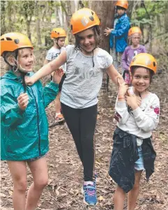  ??  ?? THREE AMIGOS: Trinity Anglican School Year 3 students Madeline Collins, Abigail Barnes and Anja Dimitrijev­ic on the low ropes course at camp.