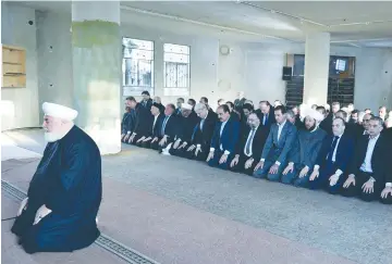  ?? (SANA/Reuters) ?? SYRIAN PRESIDENT Bashar Assad (fourth from right) prays at a mosque in a Damascus suburb yesterday.
