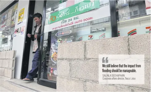  ?? WICHAN CHAROENKIA­TPAKUL ?? A flood wall built around a 7-Eleven in Phetchabur­i’s Muang district. Businesses have been preparing for months to avoid a repeat of the 2011 crisis.
