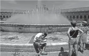  ?? SANTI DONAIRE/AP FILE ?? A man cools himself at a fountain April 27 in Seville, Spain. Given that things already are warmer than normal, scientists say, a strong El Niño could send global average temperatur­es soaring to a record high.