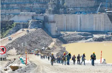  ?? CORTESÍA EPM ?? Un grupo de trabajador­es sale de la represa de Hidroituan­go ante un nuevo desprendim­iento de tierra .