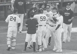  ?? MINCHILLO/AP
JOHN ?? The Yankees’ Luke Voit (59) celebrates with teammates after hitting a walkoff RBI sacrifice fly off Orioles relief pitcher Hunter Harvey in the 10th inning Saturday in New York.