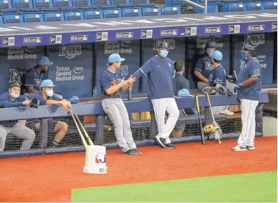  ?? MIKE CARLSON/ASSOCIATED PRESS ?? Members of the Tampa Bay Rays prepare for the start of a team scrimmage Thursday in St. Petersburg, Florida. Public health officials have mixed feelings about the safety of opening Major League Baseball season this week.