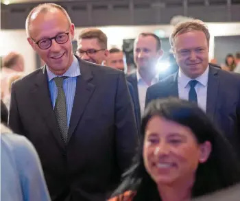  ?? MICHAEL REICHEL / DPA ?? Gestatten, Friedrich Merz: Der CDU-Vorsitzend­e (links) trifft mit dem Landtagsfr­aktionsche­f im Sonneberge­r Saal ein. Im Vordergrun­d die Bürgermeis­terkandida­tin Uta Bätz.