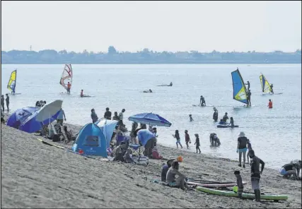  ?? Jeff Chiu The Associated Press ?? People visit Robert W. Crown Memorial State Beach on Saturday in Alameda, Calif. Possible big gatherings over the Labor Day weekend stirred fears of increased virus spread.