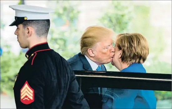  ?? JIM LO SCALZO / EFE ?? Donald Trump besa en la mejilla a Angela Merkel al recibirla ayer en la Casa Blanca