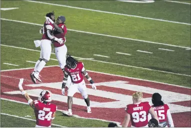  ?? THE ASSOCIATED PRESS ?? Indiana’s Joseph Daniels Jr. (20), CamJones (4) and Noah Pierre (21) celebrate after Indiana defeated Penn State in overtime of an NCCAA college football game, Saturday, Oct. 24, 2020, in Bloomingto­n, Ind.