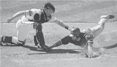  ?? PATRICK SEMANSKY/The Associated Press ?? Baltimore catcher Nick Hundley, left, tags out Toronto’s Jose Bautista, who was attempting to score on a ground ball hit by
Brett Lawrie in the eighth inning Sunday against the Orioles. The Jays beat the O’s 5-2 to earn a split of the series.