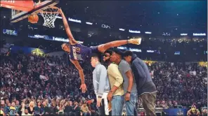  ?? USA TODAY SPORTS ?? Top: Indiana’s Glenn Robinson III leaps over teammate Paul George, a mascot and a cheerleade­r on his way to winning the Slam Dunk Contest during NBA All-Star Saturday Night in New Orleans. Above: Runner-up Derrick Jones Jr soars over Phoenix teammates...