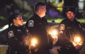  ?? Brian A. Pounds / Hearst Connecticu­t Media ?? Ansonia police officers attend a candleligh­t vigil for domestic violence homicide victim Grace Zielinska outside her former home in Ansonia on Tuesday.