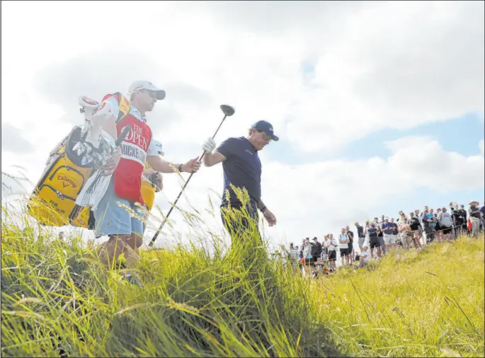  ?? Ian Walton The Associated Press ?? Phil Mickelson walks off the seventh tee during the first round of the British Open at Royal St. George’s. Mickelson was tied for last place after a rough start.