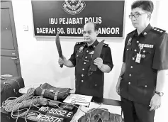  ??  ?? Abdul Aziz (left) showing the weapon and other items used in the kidnap attempt at Sierramas in Sungai Buloh. — Bernama photo