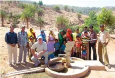  ?? PHOTO COURTESY OF MICAH SMITH ?? Micah Smith, founder and president of Global Gateway Network, kneels near a completed water well in an area three hours north of the city of Vdaipur in Rajasthan, India.