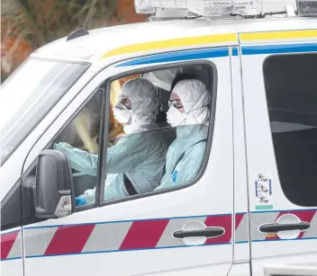  ?? Picture: GLENN FERGUSON ?? Airport paramedics in hazmat suits arrive at Avalon Airport following a coronaviru­s scare