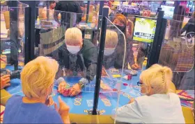  ?? ASSOCIATED PRESS FILE PHOTO ?? See-through barriers separate gamblers and a dealer at a card table at the Hard Rock casino in Atlantic City, N.J., on July 2, the first day it reopened after being closed for four months due to the coronaviru­s outbreak.