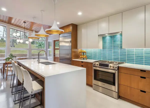  ??  ?? ABOVE: THE KITCHEN’S LOCATION REMAINS TRUE TO THE FOOTPRINT, BUT IT RECEIVED A NECESSARY DOSE OF DESIGN UPDATES. AS A PERSONAL TOUCH, BRIGHT TILE FROM CLAYHAUS TILE, LOCATED IN PORTLAND, OREGON TURNS THE BACKLASH INTO A STATEMENT. THE INTERIOR DESIGNER...