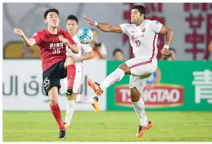  ??  ?? Guangzhou Evergrande’s Li Xuepeng, left, competes for the ball with Shanghai SIPG’s Hulk during their AFC Champions League quarterfin­al football match in Guangzhou in China’s southern Guangdong province on Tuesday. (AFP)
