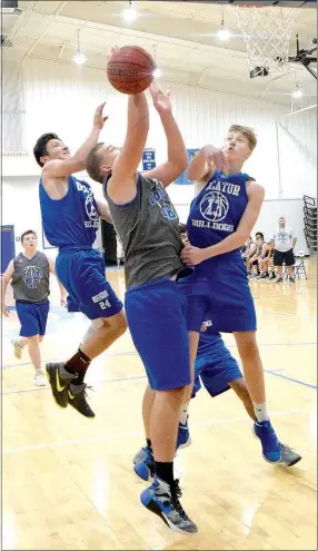  ?? Westside Eagle Observer/MIKE ECKELS ?? Kevin Garcia (Decatur 24) and Ryan Ross (Decatur 13) try to prevent a Hornet player from making a layup during the fifth game of the Colcord Scrimmage at Earp Gym in Colcord, Okla., on June 21.